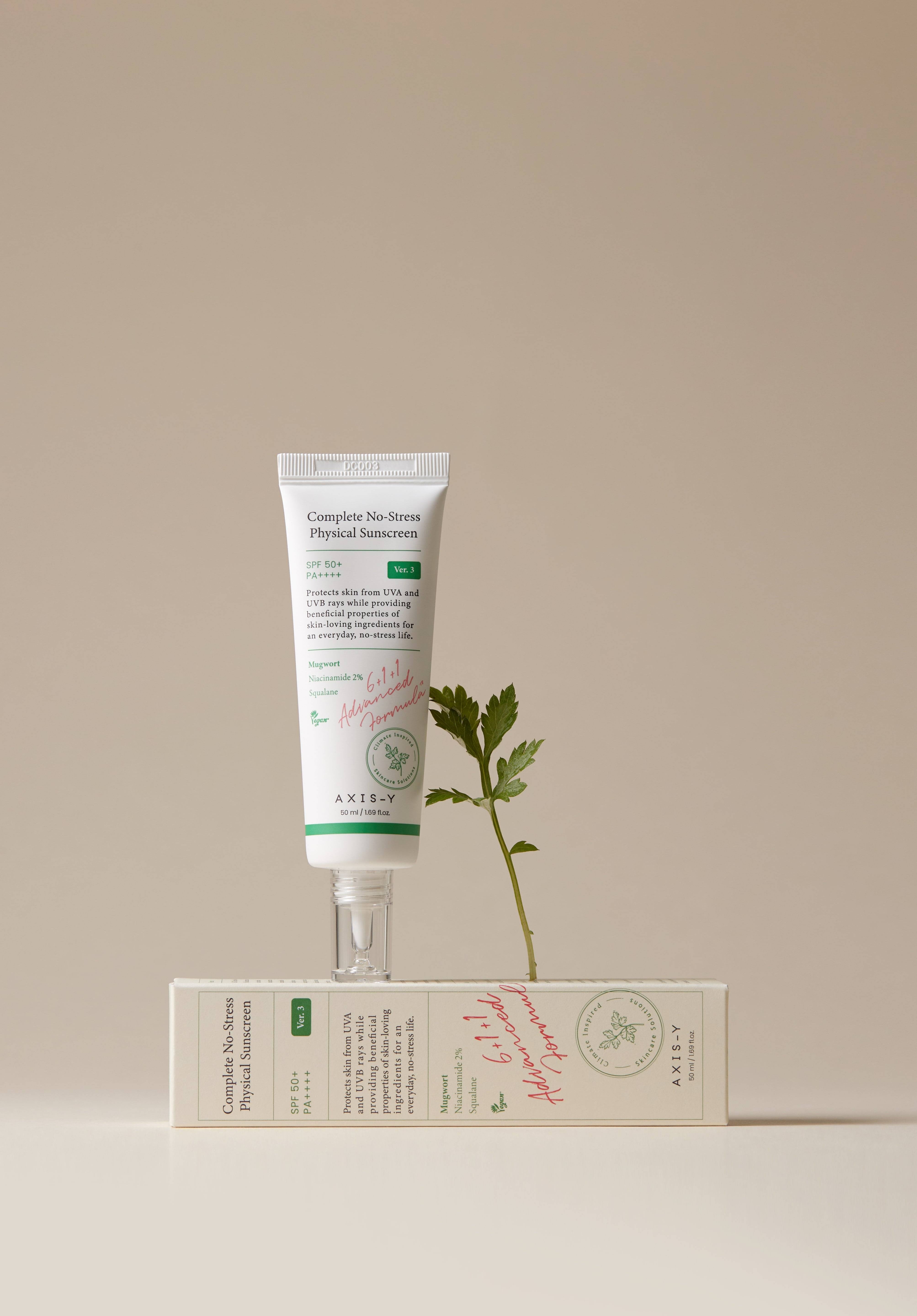Complete No-Stress Physical Sunscreen standing on its packaging with a fresh green leaf, emphasizing its natural and protective ingredients.