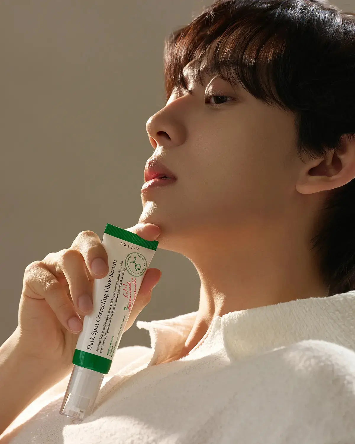 Person holding the Dark Spot Correcting Glow Serum, showcasing its lightweight texture and brightening benefits for radiant, even-toned skin.