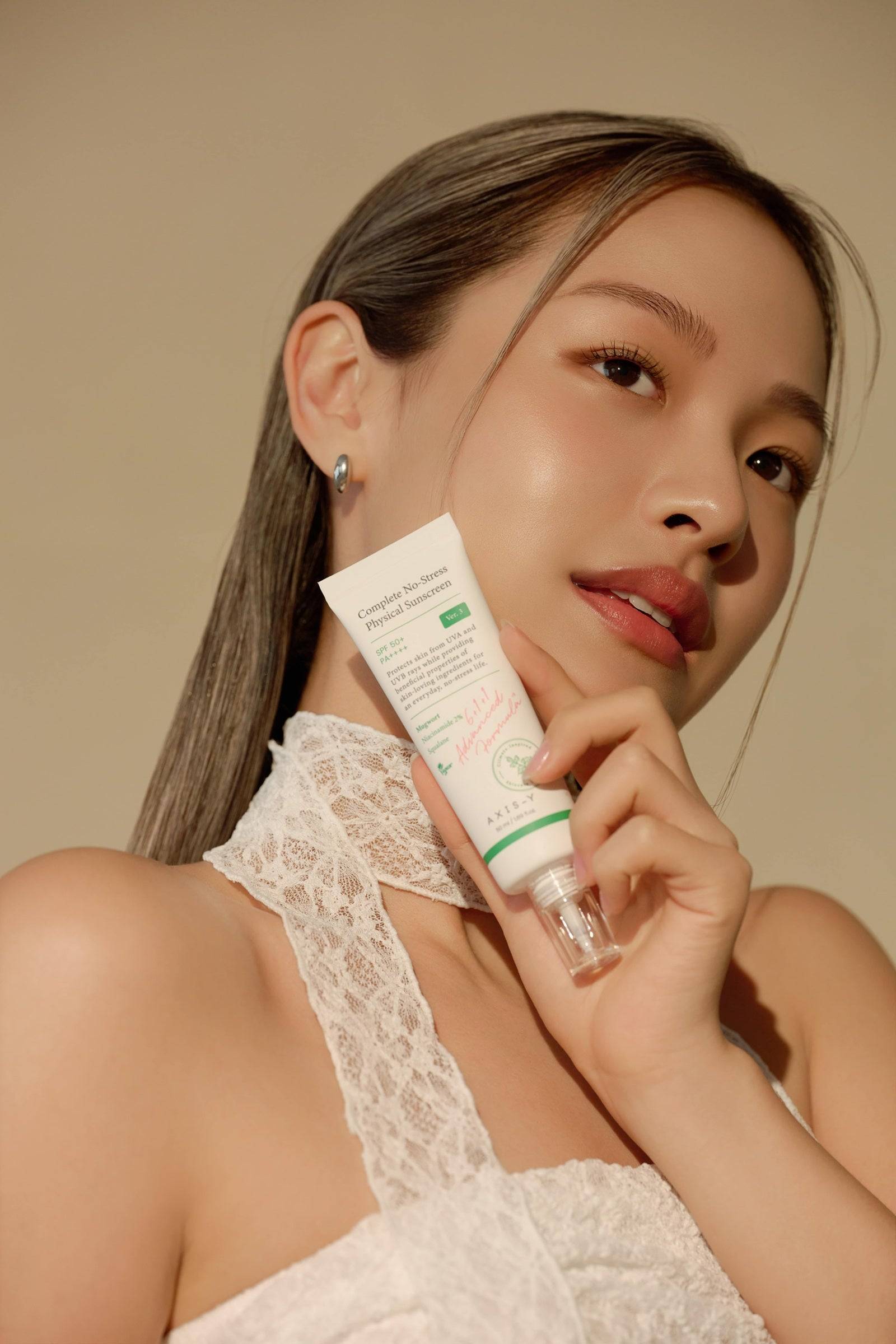 Person holding Complete No-Stress Physical Sunscreen, highlighting its lightweight, protective formula for a radiant and healthy complexion.