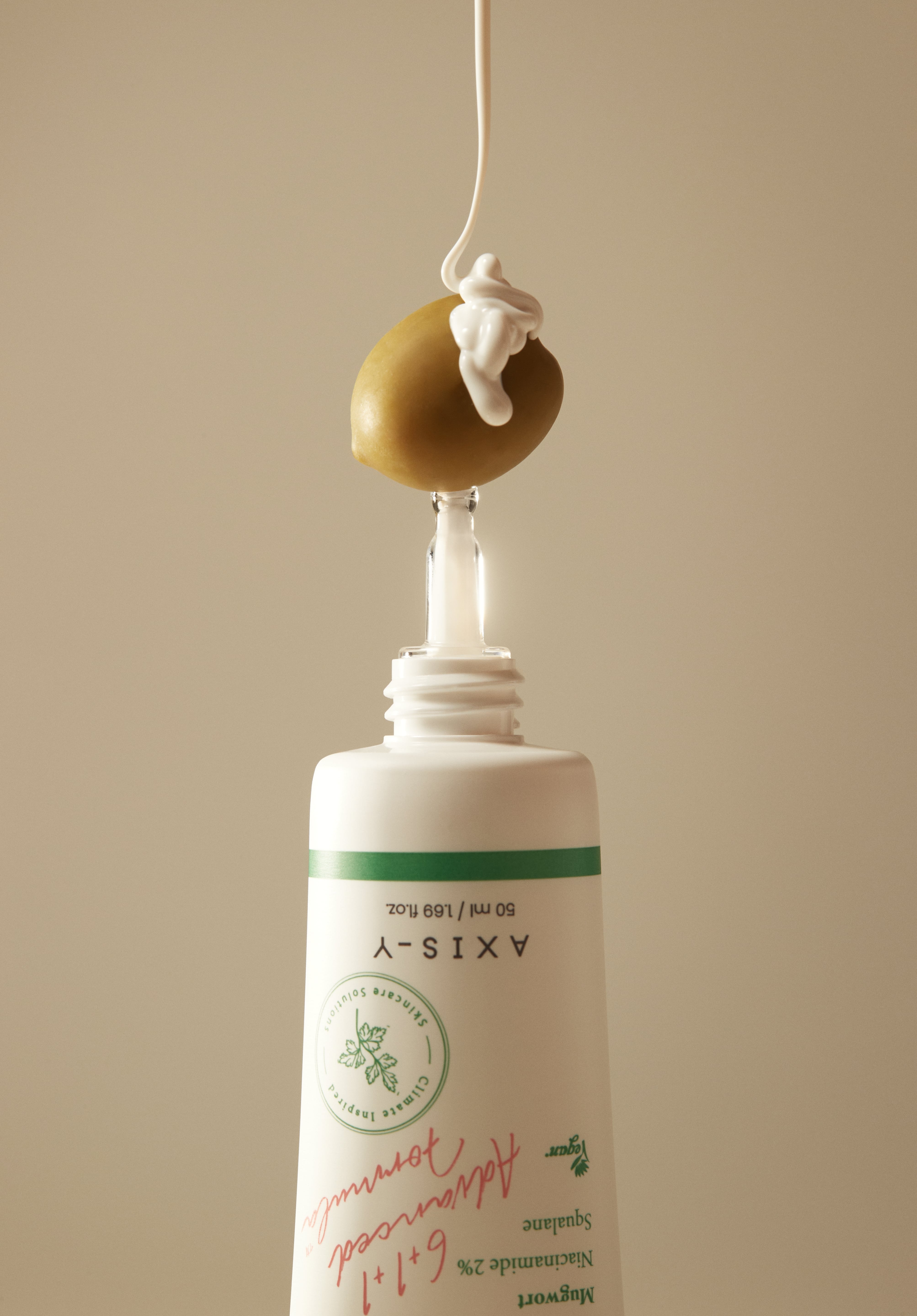 Dark Spot Correcting Glow Serum with niacinamide and squalane, artistically dispensed over an olive, symbolizing hydration and nourishment.