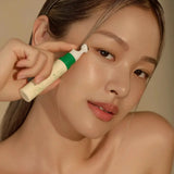 Model applying Vegan Collagen Eye Serum with a cooling applicator, promoting hydration and reducing dark circles for youthful eyes.